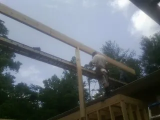 Carpenter setting a ridge beam over a new addition frame — Ice Dam Removal by Roofing Brothers in Good Hope